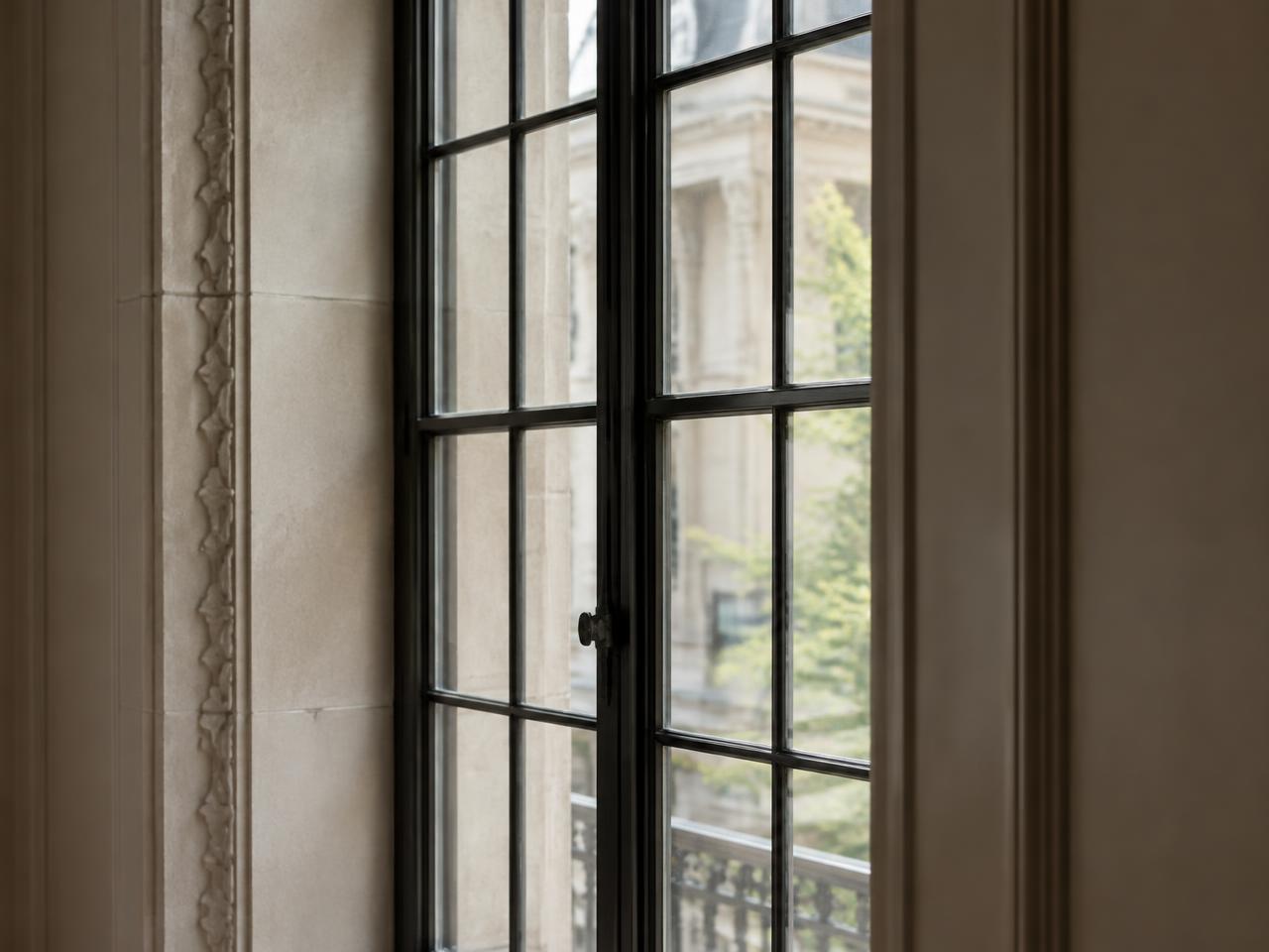 Slender steel casement window in a limestone wall